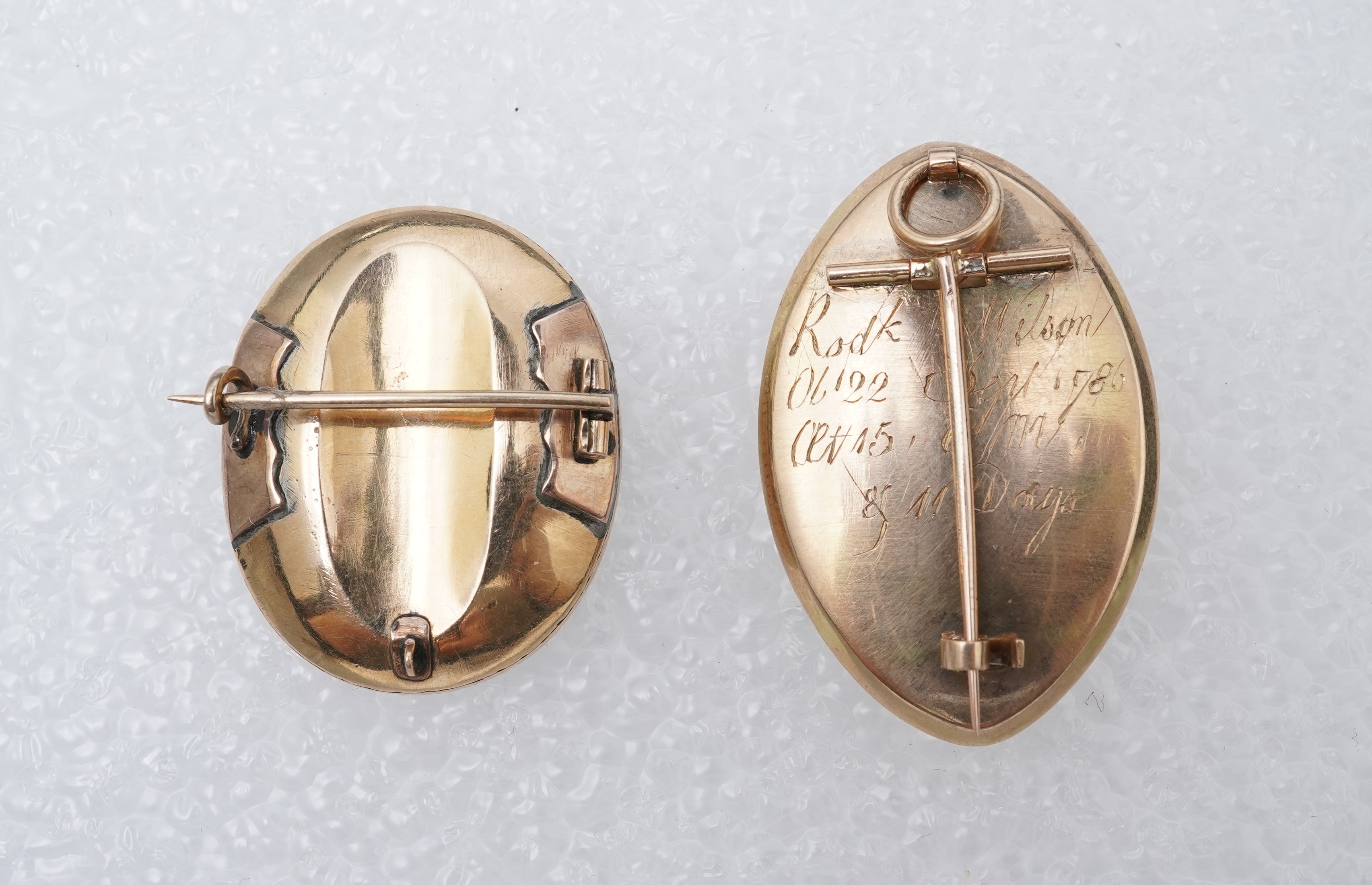 A George III ivory mourning brooch, circa 1786, and a feather work brooch, 19th century